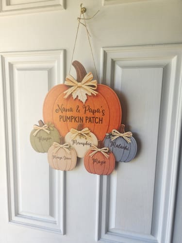 Customer's personalized wooden Pumpkin Patch door hanger hanging on a white door.