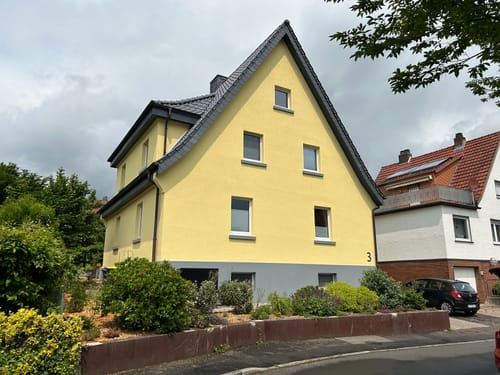 Kunden-Hausnummer WesterWerk montiert an einer hellgelben Hausfassade.