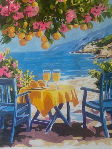 Customer's completed Surprise Painting depicting a seaside table with two drinks under lemon trees, vibrant and colorful.