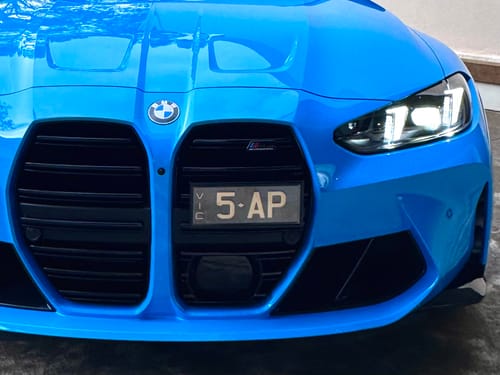 Customer's S1 Slimline Signature Number Plate Bracket installed on a blue car front bumper, showing a clean fit.