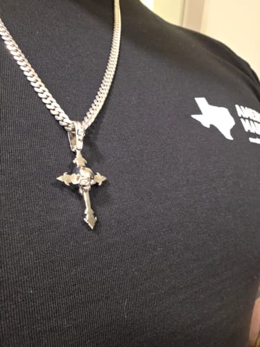 Reviewer's silver Down Your Throat Pendant featuring a cross and skull design, worn on a thick chain.