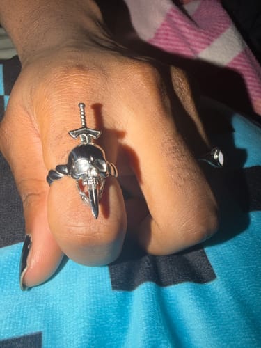 Customer's silver Nightmare Ring with a detailed skull and sword design worn on a finger