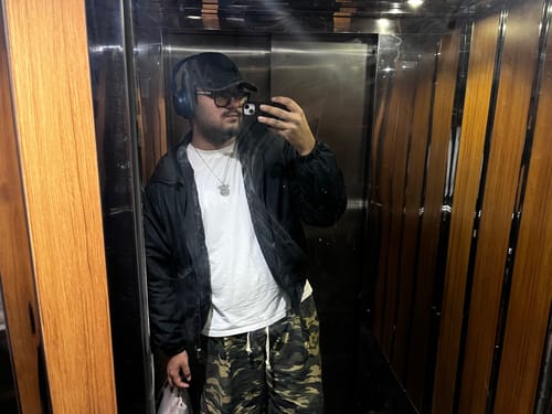 Reviewer giyen JR Full Camo Desenli Low Waist Pantolon'un asansördeki aynalı görünümü.