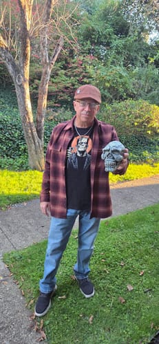 Customer wearing the Whiskey Frankenstein Monster Toast T-Shirt, holding a skull decoration outdoors.