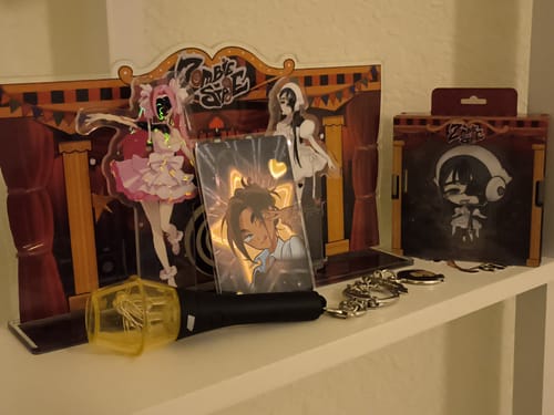 Customer's Zombie Stage acrylic stand displayed on a shelf with a clear base and collectible figurines.