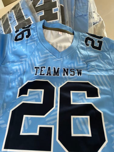 Customer's light blue and navy American football jersey with the custom name TEAM NSW and number 26 printed on the front.
