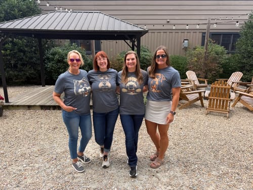 Customer's group of four people wearing gray Whiskey Dog Goldendoodle Grunge T-Shirts in an outdoor setting.