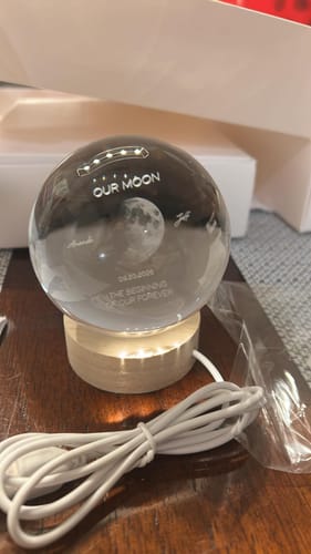 Customer's Personalized Moon Phase Crystal Ball Night Light on a round wooden base with a white power cable.