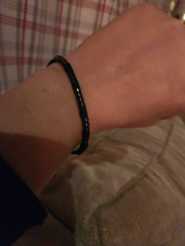Close-up of a customer's wrist wearing the black, beaded Just Breathe - Morse Code Bracelet.