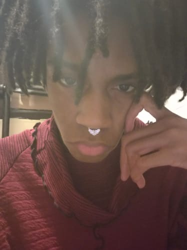 Close-up of a reviewer wearing the detailed silver Moth Septum.