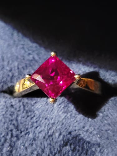 Close-up of the reviewer's ruby and gold engagement ring in its presentation box.