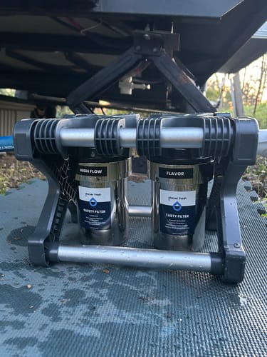 Reviewer's GlacierFresh 2-Stage Water Filter System set up on the ground under a travel trailer.