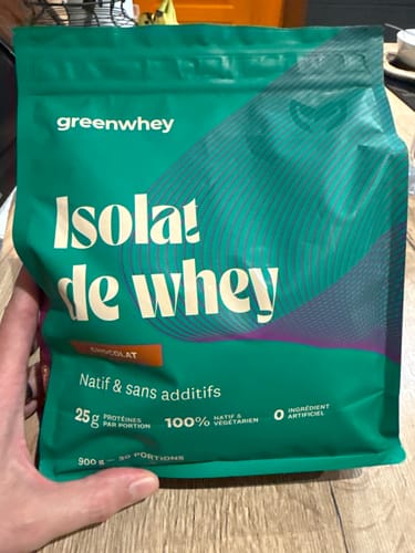 Un client tenant le sachet vert d'Isolat de Whey Native, saveur chocolat.