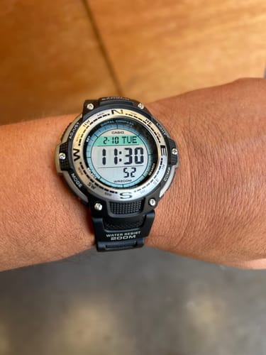 Un cliente muestra su reloj Casio SGW-100-1VEF en la muñeca. El reloj tiene correa negra y una pantalla digital positiva.