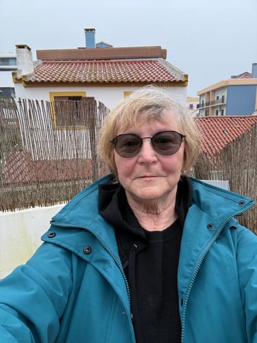 Customer layers the black Ryann Hoodie under a teal jacket, demonstrating its use for travel.