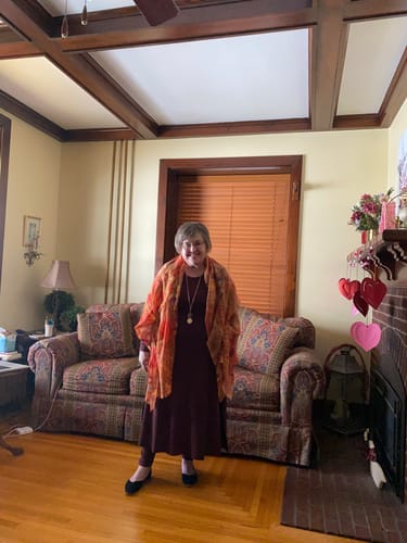 Reviewer in her living room wearing the Toasted Garnet Piper Pocket Leggings under a matching dress.