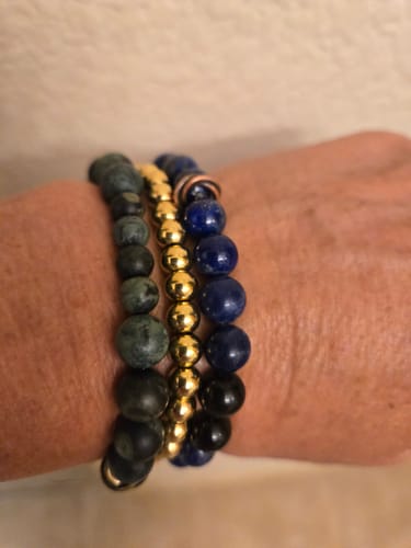 Customer's Gold - Accent Bracelet on a wrist, styled in a stack with a blue beaded bracelet and a green stone bracelet.