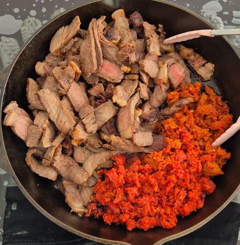 Cliente mostrando el Filete Pieza Básica en tiras, cocinado junto a chorizo en un sartén.