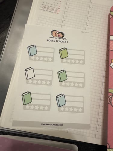 Customer's sheet of Books 2 Tracker Planner Stickers displayed on top of an open planner page.