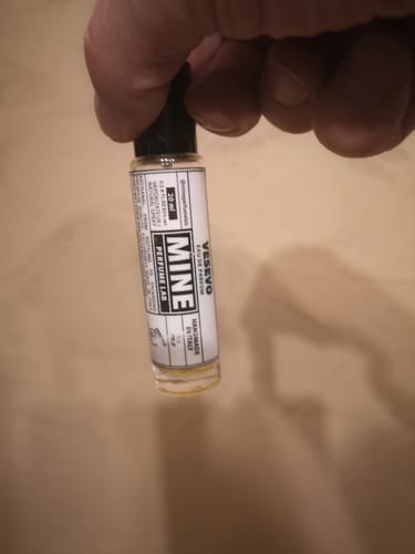 Un cliente tiene in mano una piccola e trasparente boccetta di profumo VESEVO.