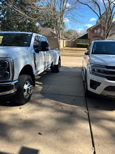 Customer's photo of a clean white truck and an SUV parked side-by-side in a driveway.