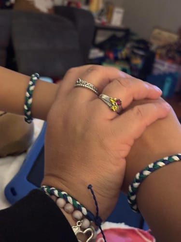 Customer and child holding hands, each wearing a matching woven DAVID Bracelet.