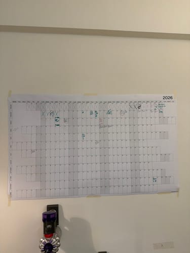Customer's large 2026 Yearly Calendar taped to a wall, with planning notes written on it.