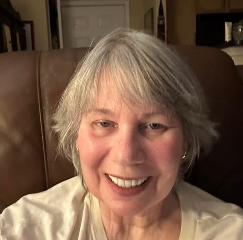 Reviewer smiling to show off their bright, white Pop On Veneers.