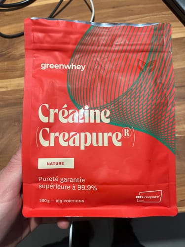 Client tenant le sachet rouge de Créatine Creapure® de greenwhey dans sa main.