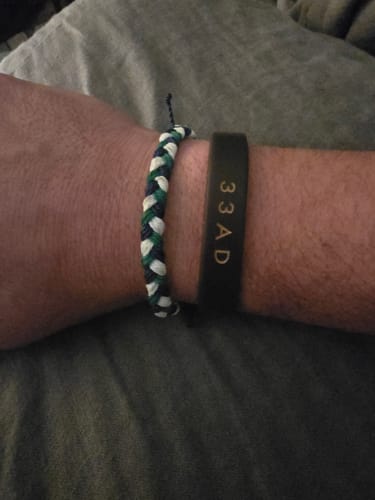 Customer wearing the woven blue, green, and white DAVID Bracelet on their wrist.