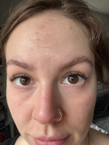 Nahaufnahme der Augen einer Kundin, die ihre mit 'seal the deal' Top Coat versiegelten Wimpernextensions zeigt.