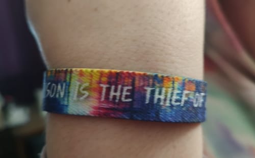 Close-up of a customer wearing the multicolored Comparison Is The Thief Of Joy Bracelet on their wrist.