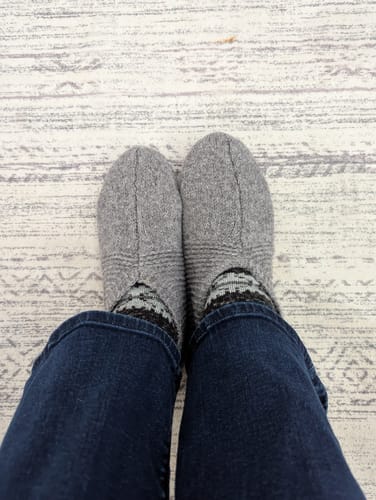 Customer's top-down view of the Gentle Grey Gripper Slippers on their feet.