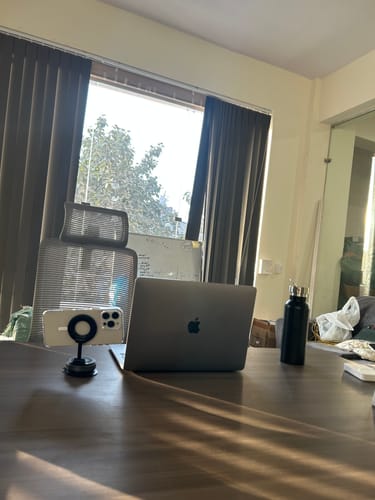 Customer's 360° MagPro Magnetic Phone Holder on an office desk, holding a phone horizontally next to a laptop.