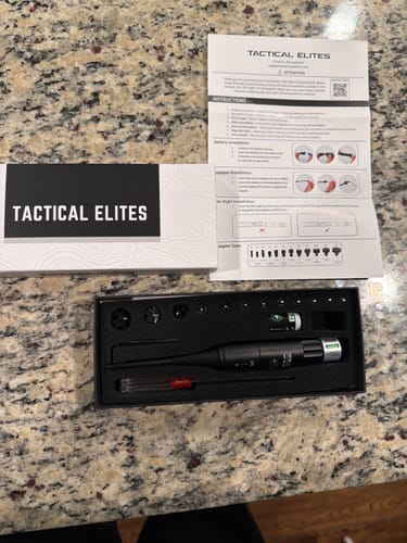 Reviewer's Site Right 2.0 Boresighter kit unboxed in its case with tools, adapters, and instructions on a counter.