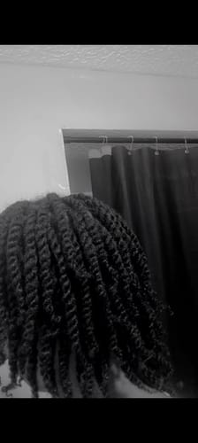 Customer's long, shiny hair styled in neat twists after using the hair care products.