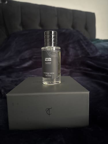 Customer's Lilium Blume Eau de Parfum bottle displayed on its matching black box against a dark, plush background.