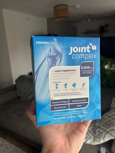 Customer holding the blue box of Joint Complex, showing the front packaging details.