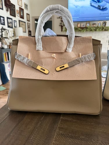 Customer's new taupe LALUVA Warkin Bag on a table, still in its protective packaging.
