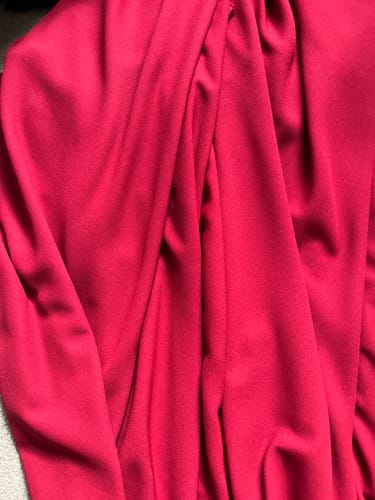 Customer's close-up of the draped, red moss crepe fabric.