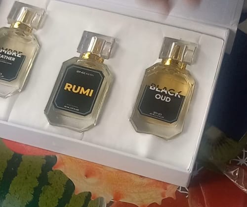 Customer's open Winter Box showing the three glass perfume bottles: Rumi, Black Oud, and Ombre Leather.