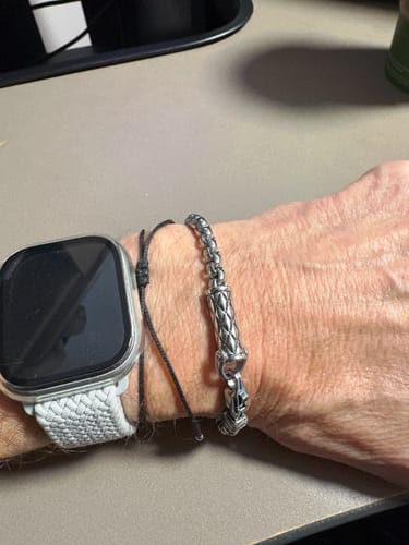 Customer wearing the steel Rugged Cylinder Urn Bracelet on their wrist, next to a watch.