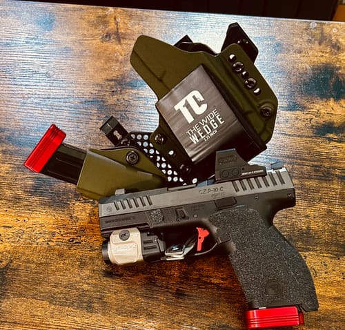 Customer's T1C Wide Wedge attached to a green holster for an appendix carry setup on a wooden table.