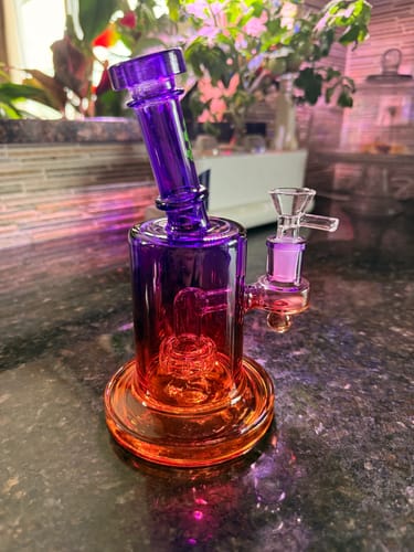 Reviewer's purple and orange Ombre Glass Showerhead Percolator sitting on a dark kitchen countertop.