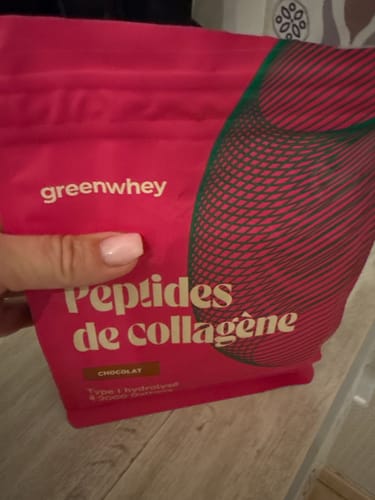 Cliente tenant le sachet rose de Peptides de Collagène, saveur chocolat, dans sa main.