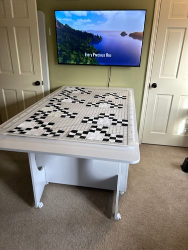 Customer's white Koala Cutting Table fully extended, with a black and white quilt top laid out on the large surface.