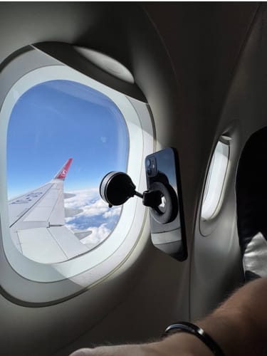 Reviewer's MagPro Magnetic Phone Holder attached to an airplane wall, securely holding a phone.