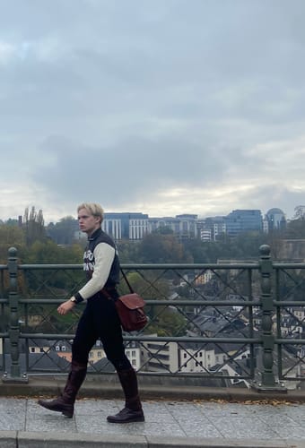 Reviewer walking on a bridge wearing the black 1920s Motor Troop Breeches tucked into tall boots.
