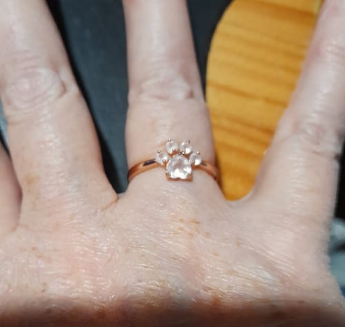 Un client montre la bague en quartz rose 'Empreinte d'Amour' portée à son doigt.