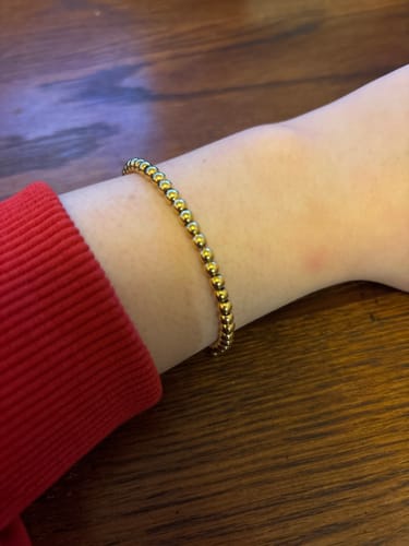 Customer wearing the shiny Niloya Beaded Gold Bracelet on their wrist.